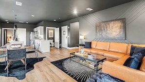 En moderne stue med sofa, sofabord og spiseområde.