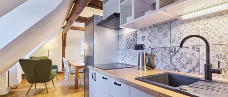 Een koelkast, een magnetron, kookgerei, borden en bestek