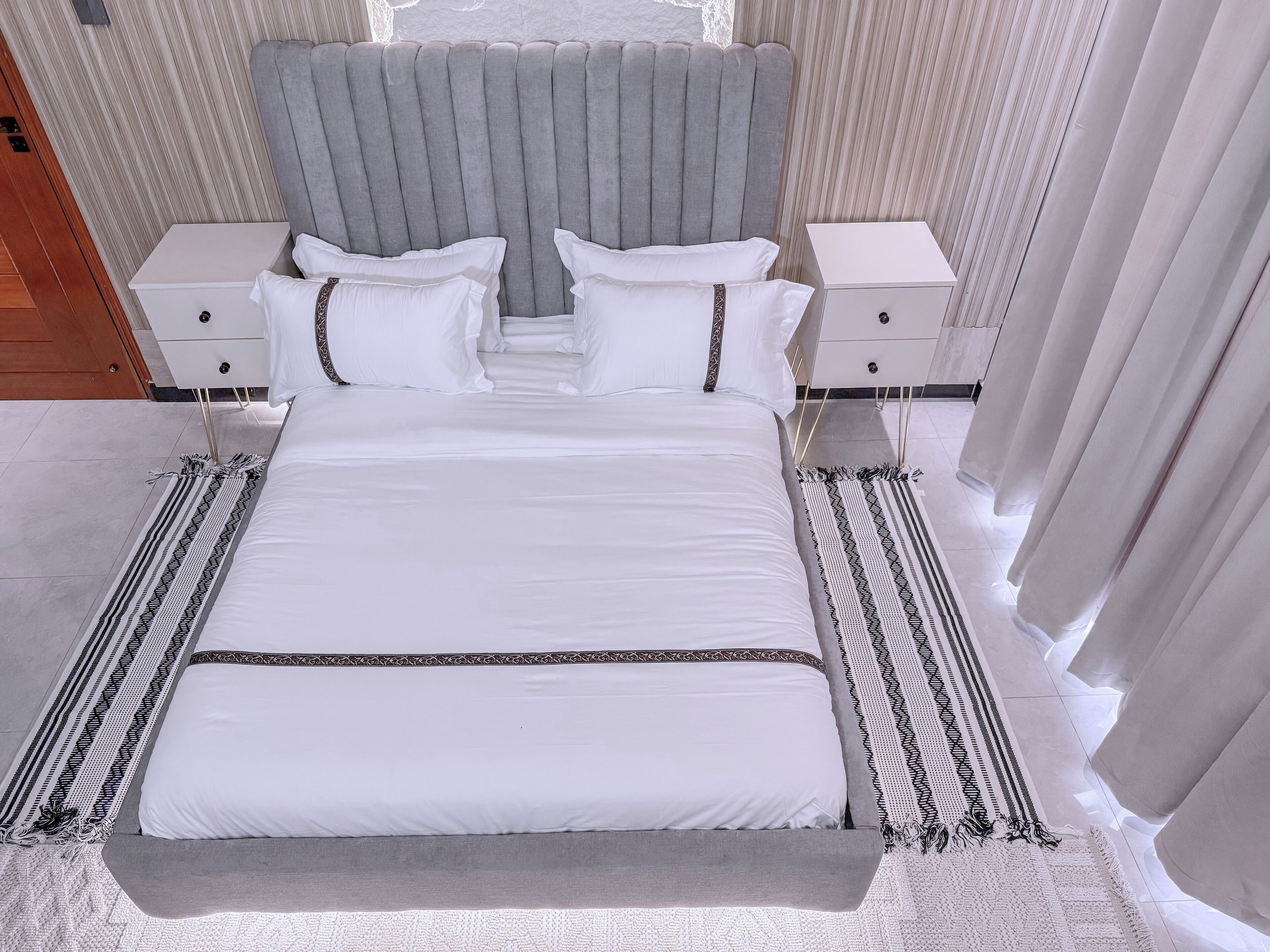Una camera da letto moderna con un letto grande, due comodini e una testiera.