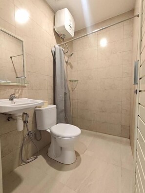 A small bathroom with a toilet, sink, and shower. - El Nipa Hotel Labuan Bajo (Labuan Bajo)