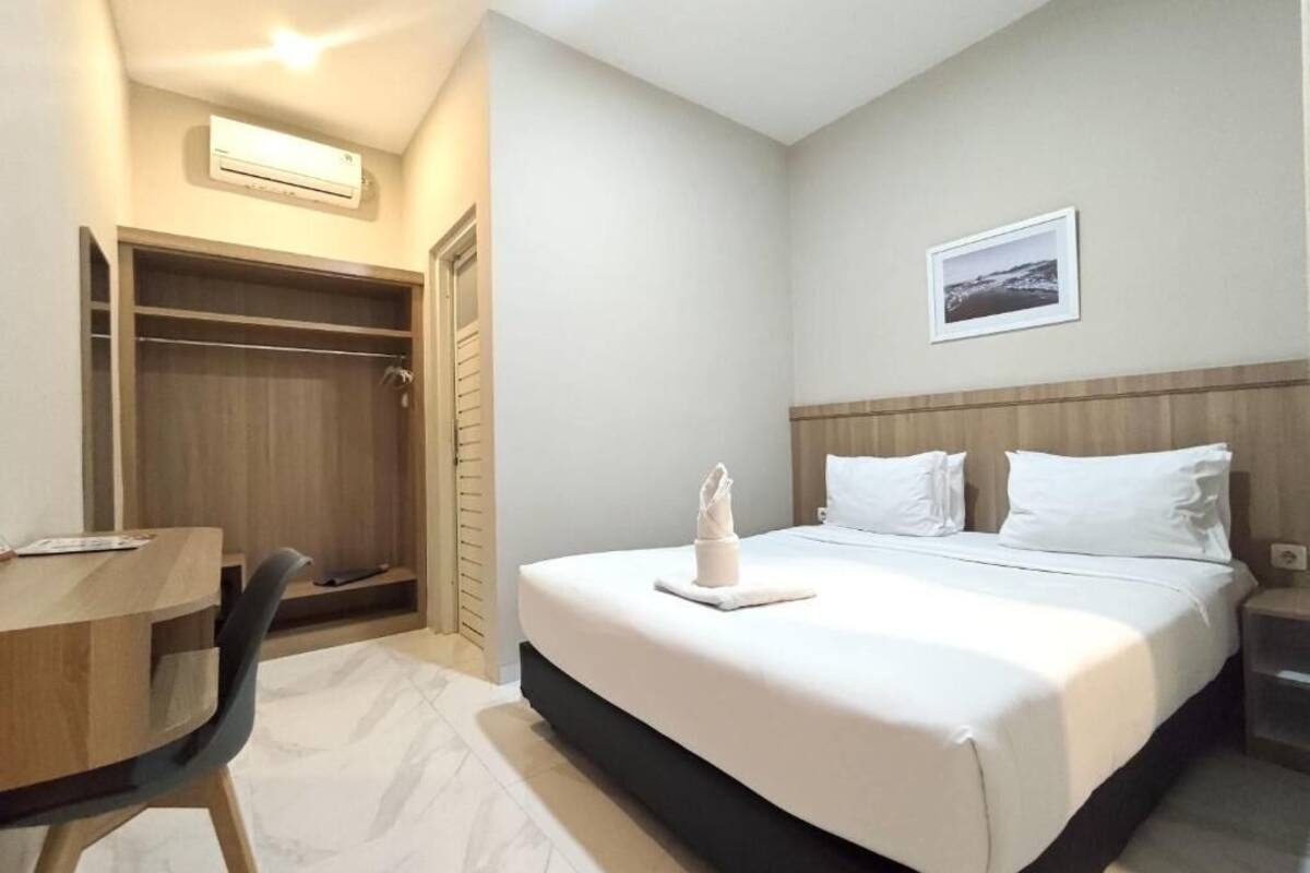 Une chambre d’hôtel comprenant un lit, une table de chevet, une chaise et une armoire.