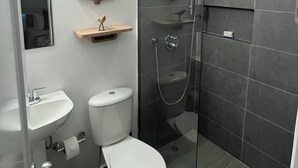 Ein modernes Badezimmer mit Toilette, Waschbecken und Dusche.