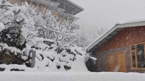 A building with a traditional architectural style, featuring a multi-tiered roof and a stone base. - Mountain View -bedroom,  bed & breakfast in welcoming Manali (Manali)
