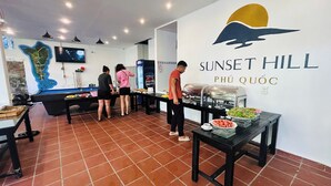 A buffet area with a wall sign reading "Sunset Hill Phú Quốc". - Sunset Hill Resort Phu Quoc (Phu Quoc)
