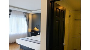 A bedroom with a bed, bedside table, and a nightstand with a lamp. - Sunset Hill Resort Phu Quoc (Phu Quoc)
