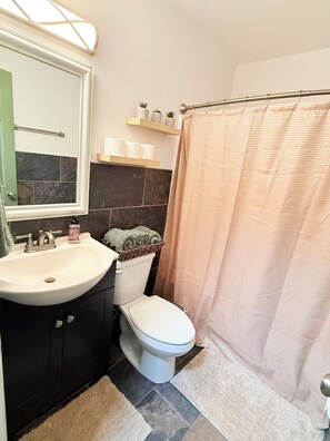 A bathroom with a sink, toilet, and shower curtain. - Coastal House Near FLETC, St Simon's & Jekyll Island (Brunswick)