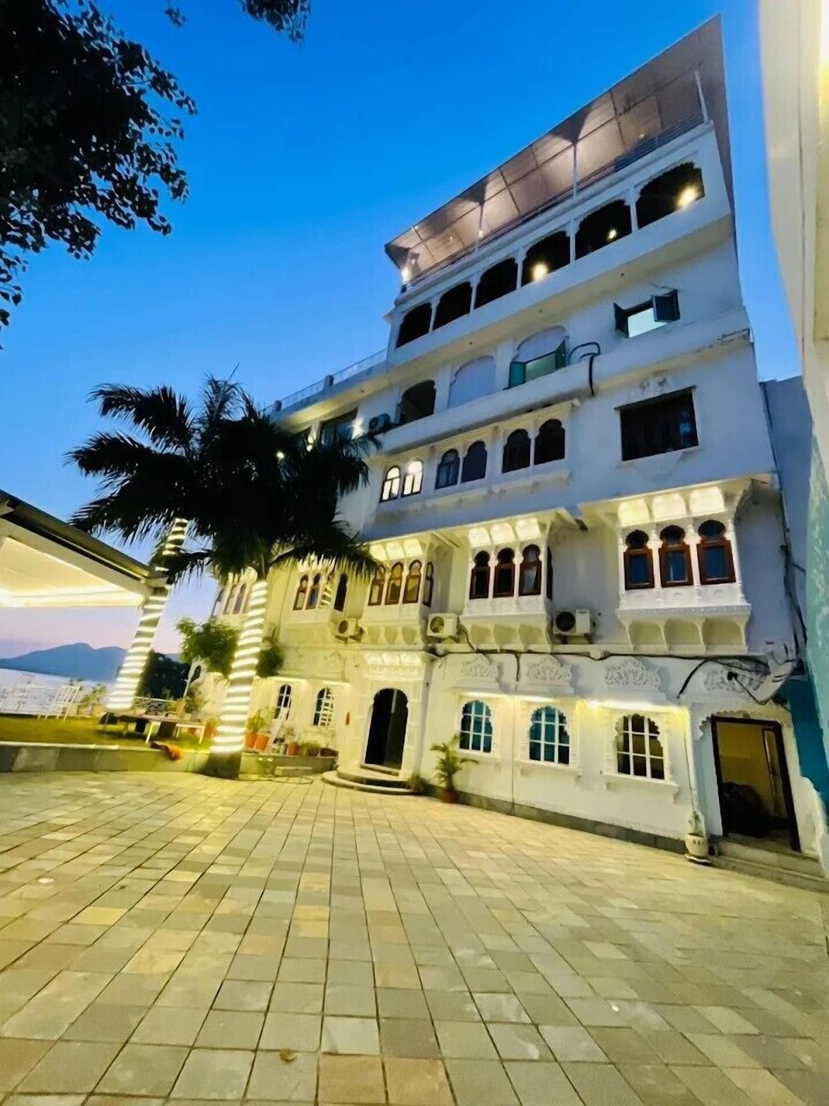 Un edificio de varios pisos con un patio interior, ventanas arqueadas y vistas al mar.