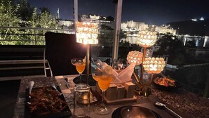 Una mesa dispuesta para comer con vista a un paisaje urbano nocturno.