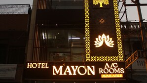 Un immeuble avec une enseigne indiquant « Thiru Annamalaiyar Residency A/C » et « Hotel Mayon Rooms », des chambres disponibles.