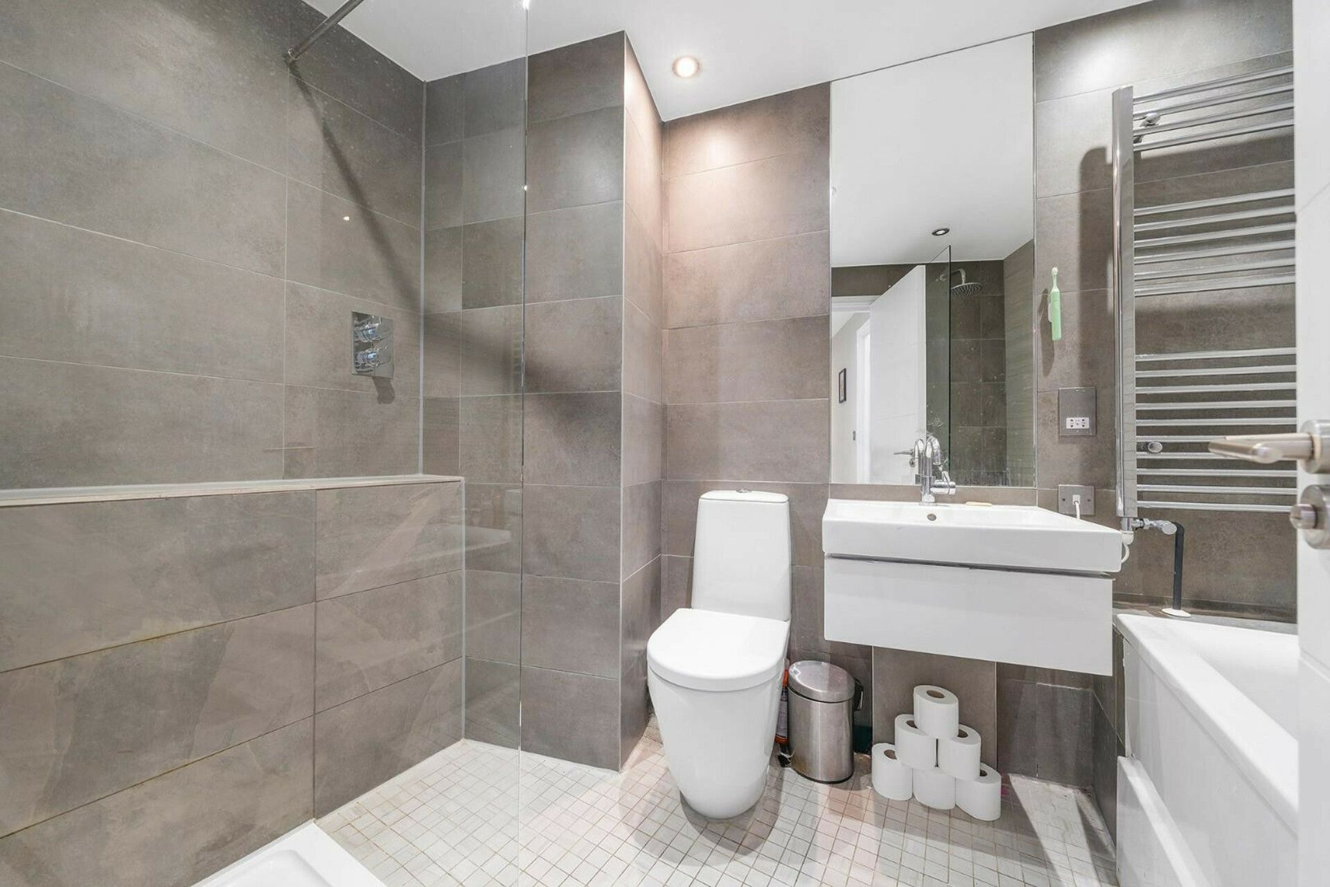 Une salle de bain moderne équipée d’une douche, de toilettes, d’un lavabo et d’une baignoire.