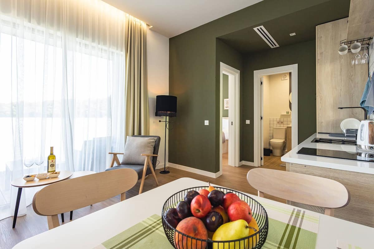 A modern living room with a dining area, a kitchen, and a bathroom.