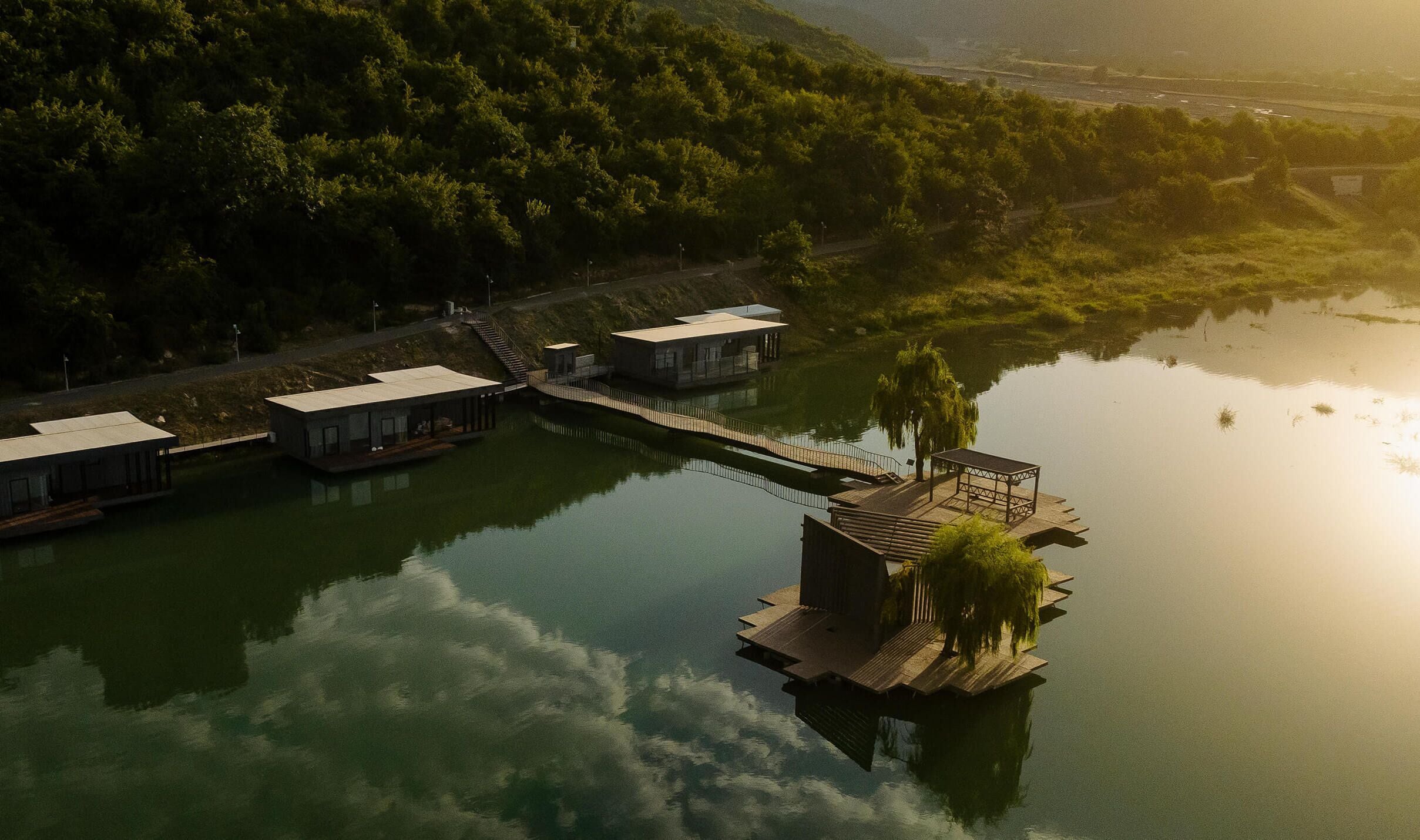 A lakeside property with floating houses connected by walkways.