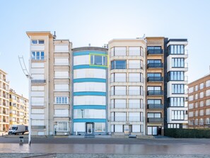Un edificio residencial de varios pisos con una estructura cilíndrica central, rodeado por otros edificios.