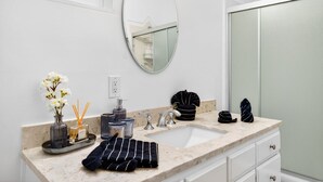 A bathroom with a white sink, a mirror, and a towel rack. - Downtown MB Gem: 2BR- 2 Blocks to the Ocean -Walk to Pier, Dining + Parking (Manhattan Beach)