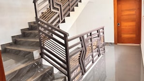 A staircase with dark marble steps and a modern metal railing. - Santiago Amazing 4bedrooms Apt for Group, Spectacular Wifi, Close to all fun (Santiago de los Caballeros)