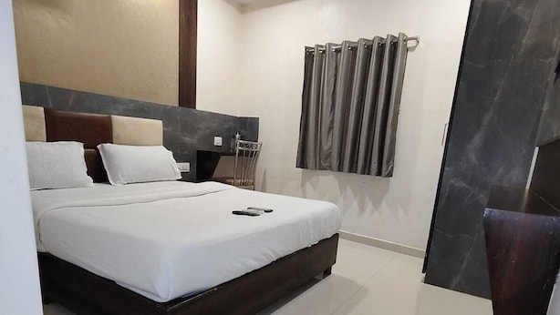 A modern hotel room with a large bed, a desk, and a ceiling fan. - HOTEL BKC NX Rooms (Mumbai)