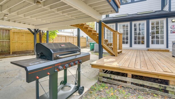 An outdoor barbecue area with a Megamaster grill, wooden deck, and a house in the background. - Home 2 Mi to Hermann Park, Zoo & Museum District! (Houston)