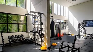 A gym with weightlifting equipment, dumbbells, and exercise machines. - UENO 906 (Sao Paulo)