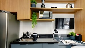 A compact kitchen with a microwave, kettle, and sink. - UENO 906 (Sao Paulo)