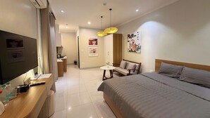 Une chambre d’hôtel moderne équipée d’un lit, d’un bureau, d’une télévision et d’un coin repas.