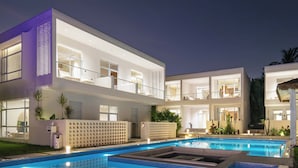 A modern two-story building with a swimming pool in front. - TANG House (Wanning)