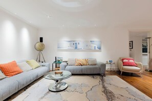 Una sala de estar moderna con dos sofás, una mesa de centro y un globo terráqueo sobre un trípode.