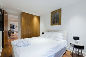 A hotel room with a bed, a painting, a lamp, and a private sign on the wardrobe. - Serene 3BDR Garden Retreat by Hampstead Heath (Greater London)