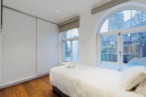 Une chambre à coucher avec un grand lit, une armoire et une fenêtre donnant sur l’extérieur.