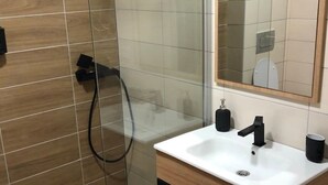 A modern bathroom with a glass shower enclosure, a white sink with a black faucet, and a wooden vanity. - Charmante Ferienwohnung in der Gemeinde Raska mit gemeinschaftlichem Parkplatz by Interhome (Kopaonik)
