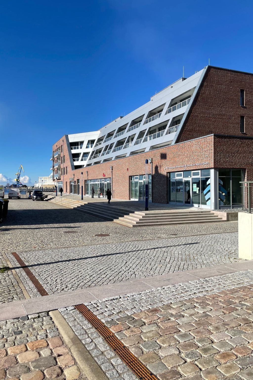 A modern building with a brick facade and a glass entrance.