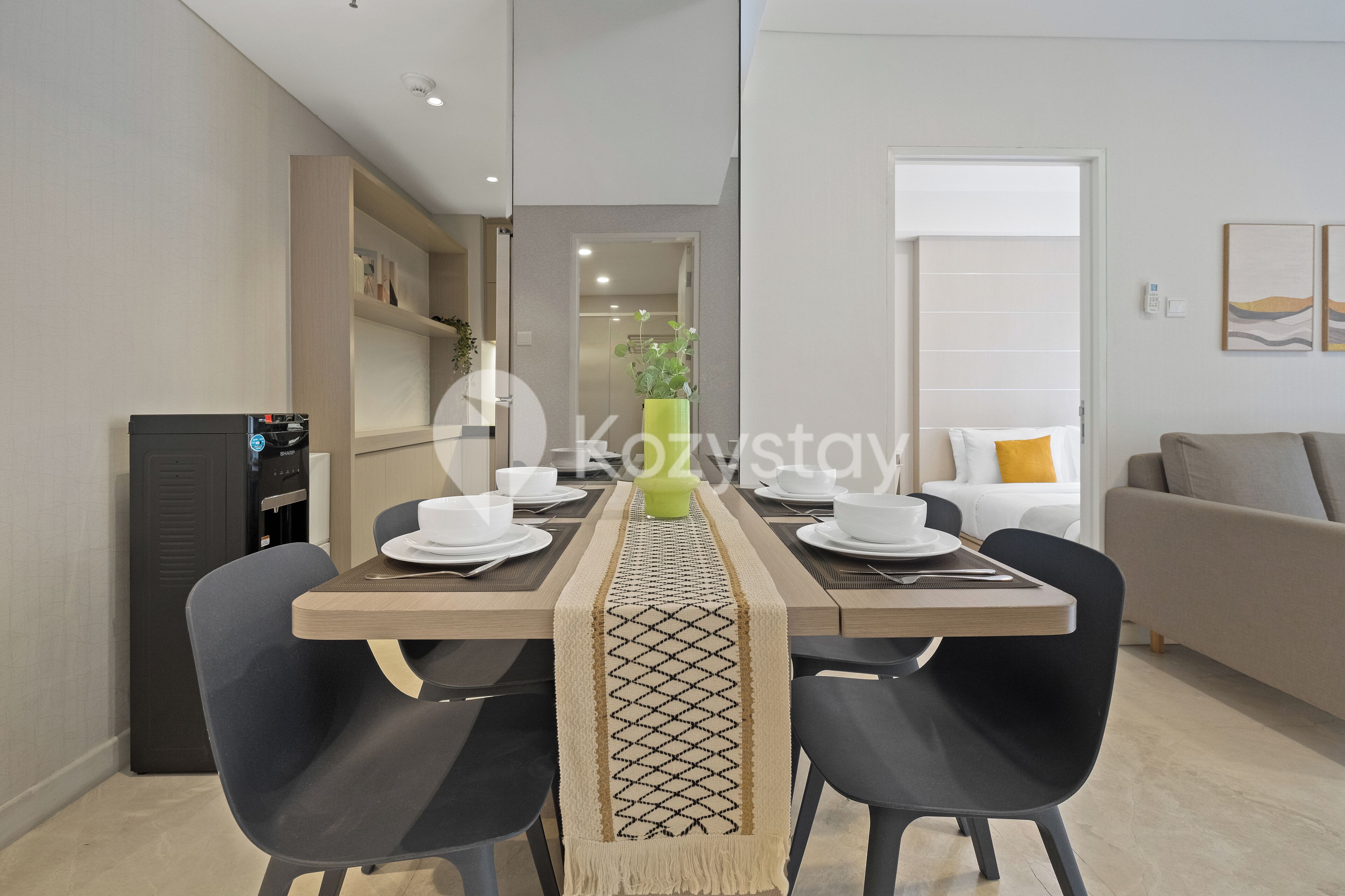 A modern dining area with a wooden table, black chairs, and a decorative runner.