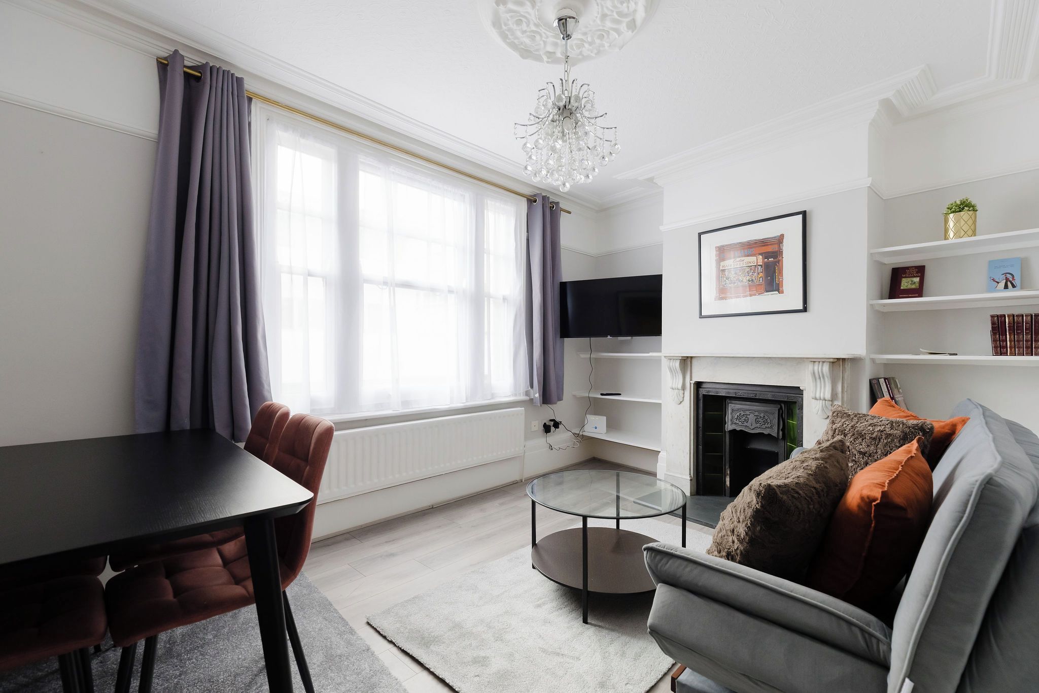 Een moderne woonkamer met een open haard, een eettafel en een bank.
