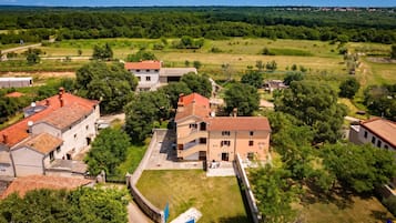 Área residencial com vários edifícios, um pátio pavimentado e vegetação ao redor.