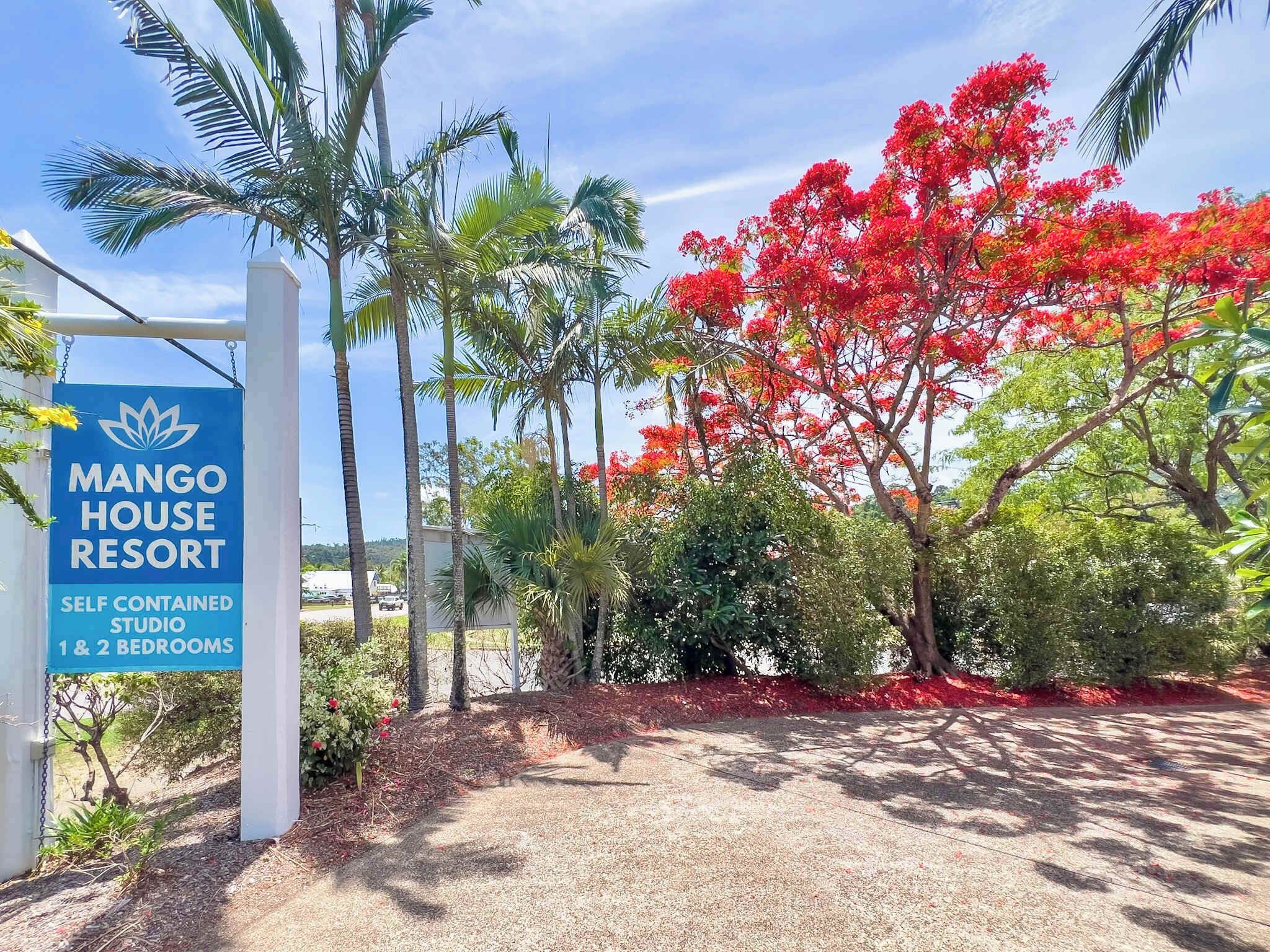 Schild für das Mango House Resort, das Studios mit Selbstversorgungseinrichtung und 1 oder 2 Schlafzimmern anzeigt.