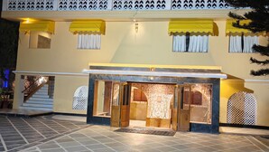 A hotel entrance with a tiled patio, a staircase leading to the entrance, and decorative awnings above the windows. - Galleria Hotel Ajmer (Ajmer)