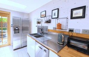 Eine moderne Küche mit Edelstahlgeräten, einer Kaffeemaschine und einem Toaster.