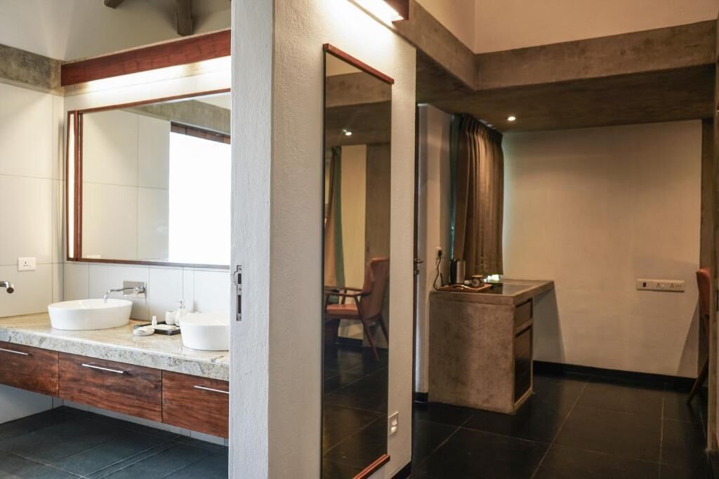 A modern bathroom with a large mirror, two sinks, and a vanity with drawers.