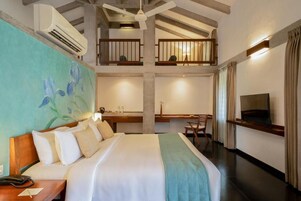 Une chambre d’hôtel avec un grand lit, un bureau, un balcon et une télévision.