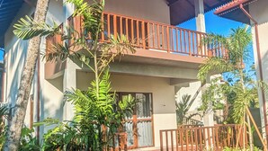 A two-story house with a balcony, surrounded by lush greenery and palm trees. - Arinna Beach Resort (Tangalle)