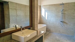 A modern bathroom with a large mirror, a rectangular sink, a pedestal sink, and a shower with a handheld showerhead. - Arinna Beach Resort (Tangalle)