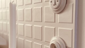A wall with a grid of square panels and two electrical outlets. - Maison LYO - "Lys" Romantic Luxury Suite (Cannes)
