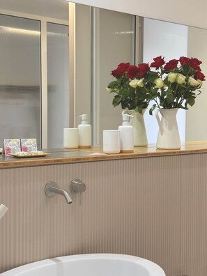 A bathroom with a bathtub, a mirror, and a vanity with toiletries. - Olivier (Cannes)