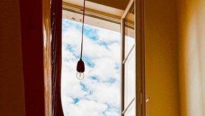Una escalera con un ventanal que da a un cielo luminoso.
