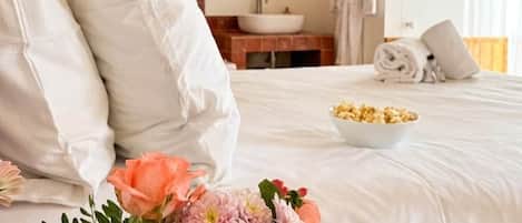 Una habitación de hotel con cama, baño y espejo.