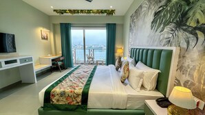 Ein Hotelzimmer mit Bett, Schreibtisch, Stuhl, Fernseher und einem Balkon mit Blick.