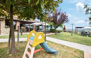 A playground with a slide and a picnic area with tables and umbrellas. - 3 bedroom amazing home in Frazione Marcellano (Frazione Marcellano)