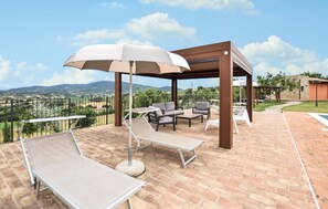 An outdoor patio with lounge chairs, a pergola, and a view of the countryside. - 3 bedroom amazing home in Frazione Marcellano (Frazione Marcellano)