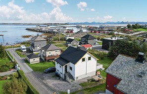 A coastal village with houses, a dock, and a road leading to the water. - Awesome home in Harøya (Harøya)