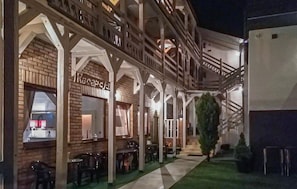A hotel with a reception area, outdoor seating, and a staircase leading to upper floors. - Lovely apartment in Leba with WiFi (Leba)