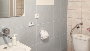 Kylpyhuone, jossa on pesuallas, wc ja käsienkuivaaja.